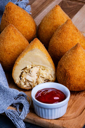 Traditional fried coxinha stuffed with chicken and a glass of cold soda.の写真素材