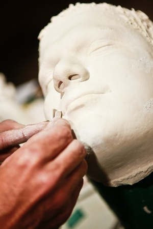 Artist working on plaster cast of a human face. の写真素材