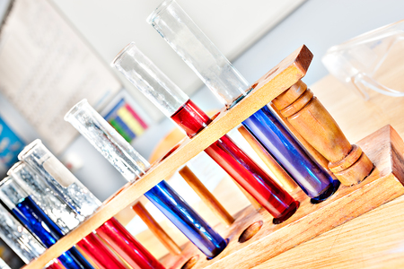 Sample test tubes with liquid in a wooden rack at a science laboratory closeupの写真素材