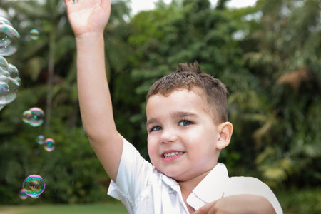 child wearing white t-shirt  waving while playing in the garden