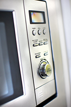 Modern oven control panel close up with buttons and knob close up of a modern kitchen