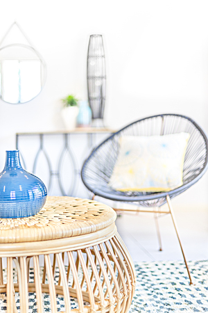 Modern blue color bottle with shine, floor has carpet, walls are white color, garden can see through windows, pillow on the chair.の写真素材