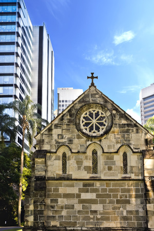 Front of an old church from modern city buildings with sky including treesのeditorial素材
