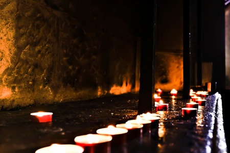 Dark and dirty stone room with flashing candles illuminating the shiny floorのeditorial素材