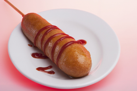 Big sausage with some designs, sweet sausages including sauce, very shiny look, background is pink color, dining table of a luxury hotel or house.の写真素材