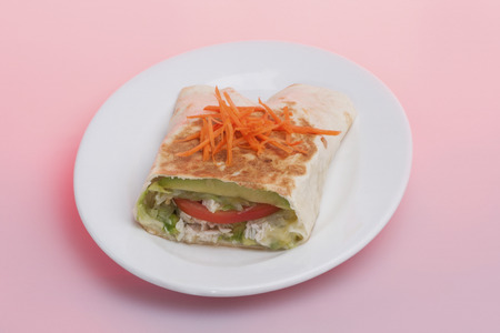 Carrot and tomato mixed bun on plate, hot burger including fish and vegetable, very tasty look, background is pink color, dining table of a luxury hotel or house .の写真素材