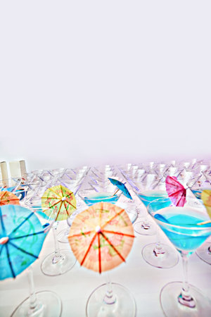 Close up of drinks and glasses with umbrella straws in them to be served in party, evening time festivalの写真素材