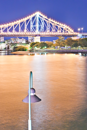 Yellow river and a bridge with Street light at night  with blue sky in the Brisbane City, Queensland, Australia.のeditorial素材