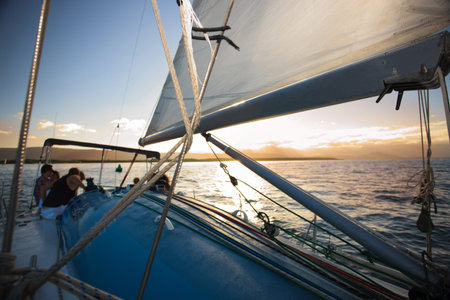 A dinghy yacht on the sea with people onboard