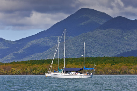 A sailing yacht with mountains in the background