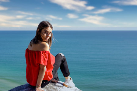 Young caucasian stylish woman in red enjoying her summer vacation in the tropical ocean coast....