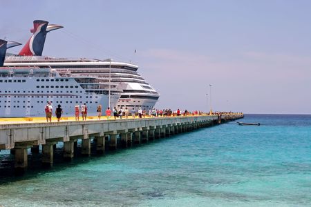 A pair of cruise ships are docked at the port in Costa Maya, Mexico in the Caribbean on a beautiful sunny day.の写真素材