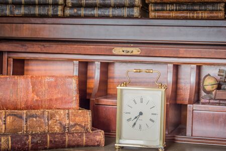 old clock on shelf with old booksの写真素材