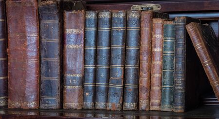 old books placed on wooden shelfの写真素材
