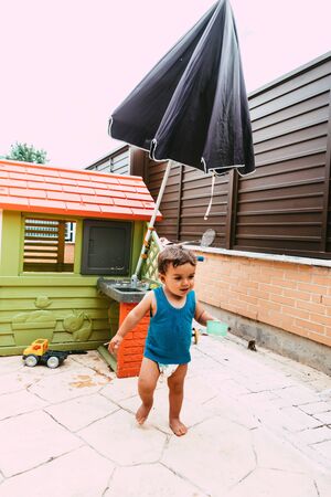 little boy playing with bucket and water at home confinement covid19の写真素材
