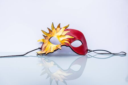 Venetian mask on white background with reflection in the lower halfの写真素材