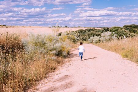 child running along a rural road enjoying nature without any digital screenの写真素材