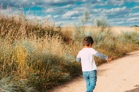 child running along a rural road enjoying nature without any digital screenの写真素材