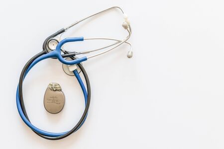 two blue and black stethoscopes on a white background with pacemaker batteryの写真素材