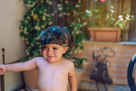 portrait of a child 18 months old wearing a hat and with the background out of focus.の写真素材