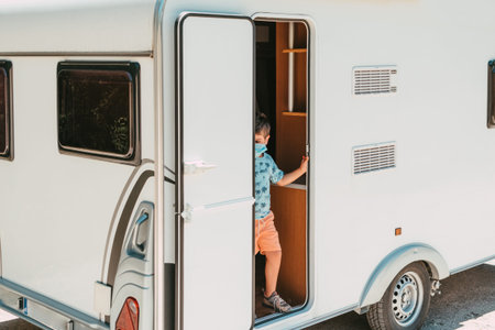 child in caravan door with mask on tripの写真素材