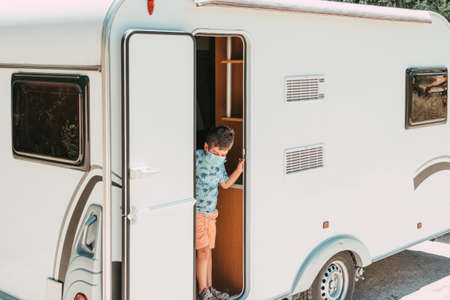 child in caravan door with mask on tripの写真素材