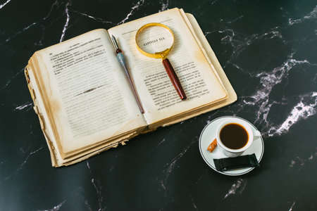 open book with candlelight, incorporates a camera, clock and a cup of coffeeの写真素材