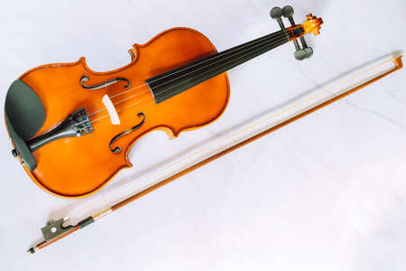Violin parts. Bow first on white marble background. Selective focus.の写真素材