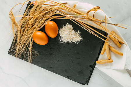 eggs, flour and wheat branches the basic ingredients of bread. focus selective.の写真素材