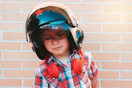 portrait kid listening to music with headphones on brick wallの写真素材