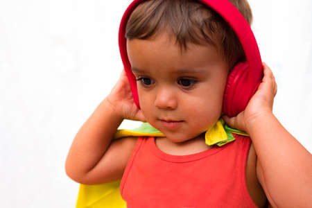 Portrait of a child listening to music with headphones on a white backgroundの写真素材
