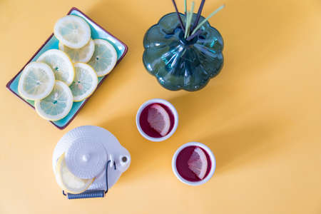 Red tea with lemon on a yellow backgroundの写真素材