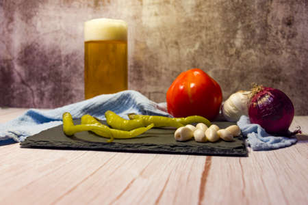 Still life snacks, tapas, chilli peppers, garlic, tomatoes, onions and garlic.の写真素材