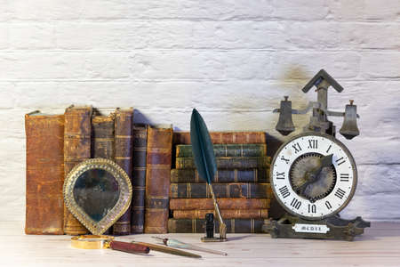 Antique watch along with antique books and vintage writing pen.の写真素材