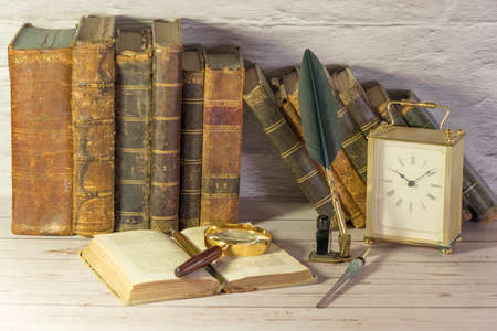 Antique watch along with antique books and vintage writing pen.の写真素材
