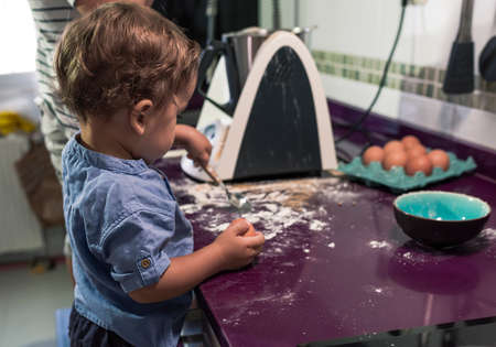 Two children preparing pancakes with a kitchen robot.の写真素材