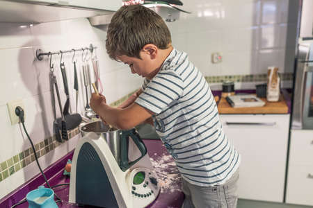 Two children preparing pancakes with a kitchen robot.の写真素材