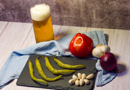 Spanish tapa of beer with chilli peppers, tomatoes and garlic.の写真素材