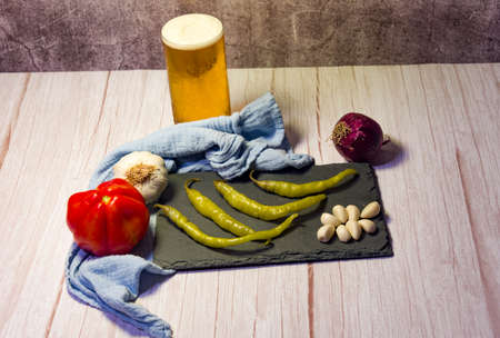 Spanish tapa of beer with chilli peppers, tomatoes and garlic.の写真素材