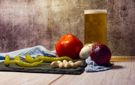Spanish tapa of beer with chilli peppers, tomatoes and garlic.の写真素材