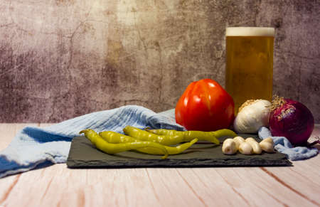 Spanish tapa of beer with chilli peppers, tomatoes and garlic.の写真素材