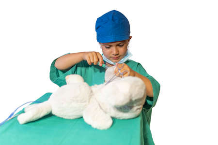 concept of a child's vocation playing doctor-surgeon operating a teddy bear.の写真素材