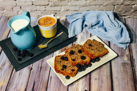 Still life of wild fruit cake with cup of milk with cocoa and milk jug.