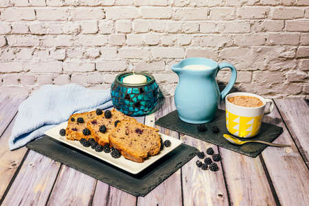 Still life of wild fruit cake with cup of milk with cocoa and milk jug.の写真素材