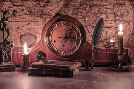 still life wind-up clock and antique books on a vintage worldの写真素材