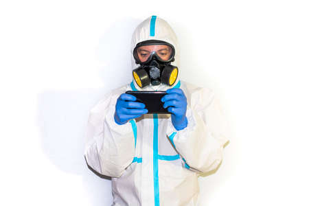 doctor in safety suit on white background. protection against coronavirus. mobile phone.の写真素材