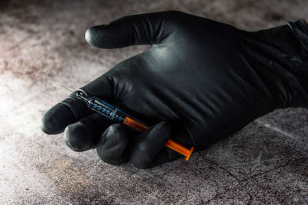 application of botox in pre-filled syringe in hand with black latex glovesの写真素材