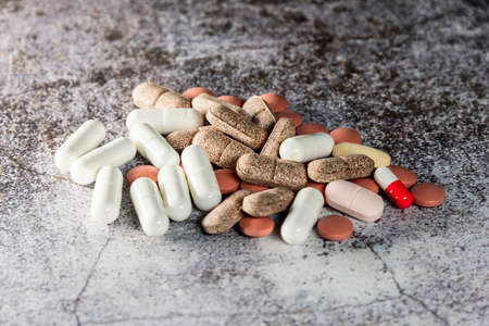 pile of mixed pills and tablets in the foregroundの写真素材