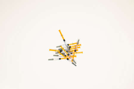 several syringes of heparin forming a mound in the center of the image with a white backgroundの写真素材