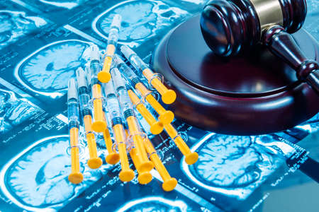 JUDGE'S MALLET TOGETHER WITH MAGNETIC RESONANCE AND SEVERAL SYRINGES. CONCEPT OF JUSTICE APPLIED TO HEALTH. FOCUS SELECTIVE.の写真素材